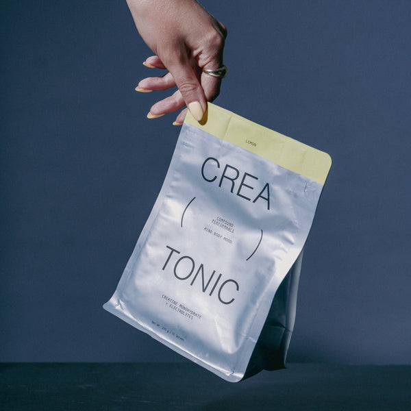 Hand holding a Creatonic pouch against a dark background